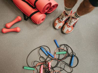 Neatly arranged jump ropes and mats on the floor.